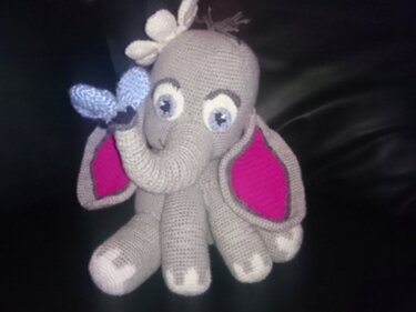 Gehäkelter grauer Amigurumi-Elefant mit rosa Ohren und blauem Schmetterling