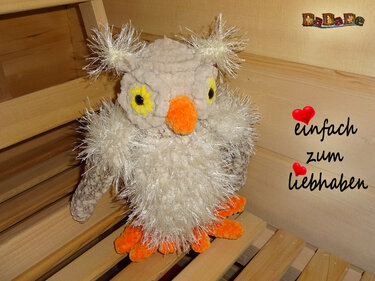 Kuschelige beige Amigurumi-Eule mit flauschigem Brustflaum und orangefarbenem Schnabel