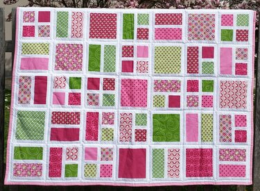 Quilt mit weißem Raster und rosa-grünen Rechtecken und Quadraten