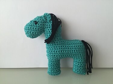 Türkises Amigurumi-Pferd mit schwarzer Mähne und Schweif an Schlüsselring
