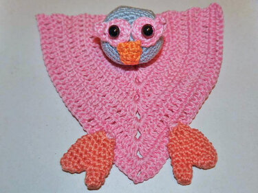 Gehäkeltes rosa Eulen‑Schmusetuch mit hellblauem Kopf und orangefarbenem Schnabel und Füßen