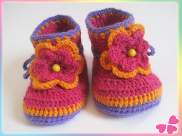 Gehäkelte Baby-Booties in Pink, Orange und Lila mit Blumenapplikation