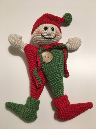 Zweifarbiger Amigurumi‑Wichtel mit rotem und grünem Bein und Holzknopf