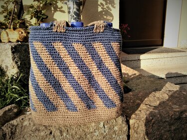Rechteckige gehäkelte Henkeltasche mit kurzen Griffen und diagonalen blauen und beigen Streifen
