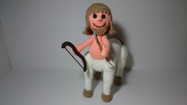 Gehäkelter Kentaur-Amigurumi in Pfirsich und Weiß mit Bogen und Pfeil