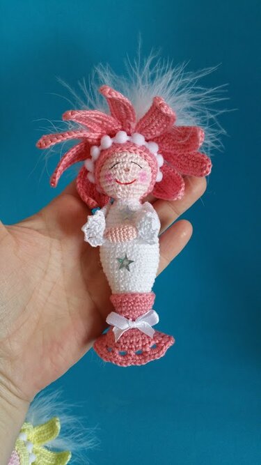Gehäkelte Amigurumi-Meerjungfrau in Rosa und Weiß mit Blütenhaube und Stern