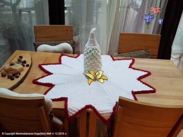 Stern-Deckchen gehäkelt in Weiß mit rotem Rand und kleinem Tannenbaum als Tischdekoration