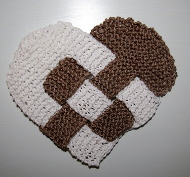 Gestricktes Herz in geflochtener Optik, weiß und braun, auf hellem Hintergrund