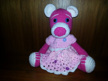 Gehäkelter pinker Amigurumi-Bär mit rosa Kleid und blauen Augen