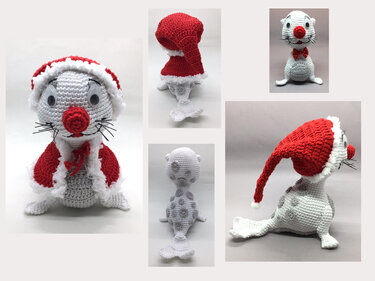 Gehäkelte weiße Robbe mit roter Weihnachtsmütze und Mantel auf hellem Hintergrund