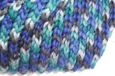 Nahaufnahme gestrickter Loop-Schal in Blau, Türkis und Grau