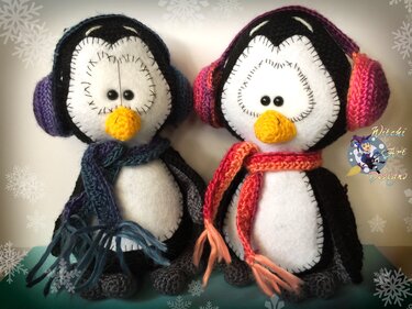 Zwei gehäkelte Pinguin-Amigurumi mit bunten Ohrenschützern, Schals, Filzgesichtern und gelben gehäkelten Schnäbeln