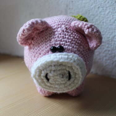 Rosa gehäkeltes Amigurumi‑Schwein mit weißer Schnauze und schwarzen Augen