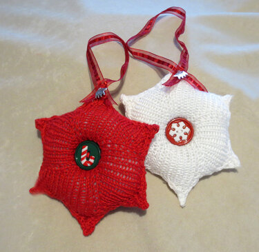 Roter und weißer gestrickter Sternanhänger mit Band und Knopf