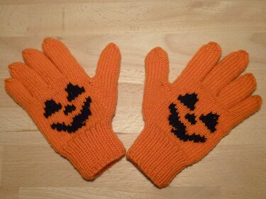 Orangene gestrickte Kinderhandschuhe mit schwarzem Kürbisgesicht, Paar