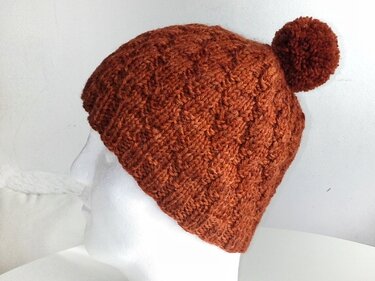 Rostbraune, gestrickte Bommelmütze mit Strukturmuster und Pompon