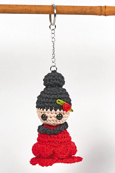 Gehäkelter Amigurumi‑Flamenco mit rotem Kleid und schwarzem Dutt am Schlüsselring