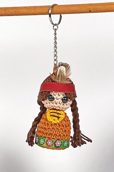 Gehäkelter Amigurumi-Schlüsselanhänger in Puppenform mit Zöpfen, rotem Stirnband und Feder