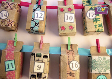 Recycelte Papierkästchen als Adventskalender, nummerierte Schachteln an bunten Bändern
