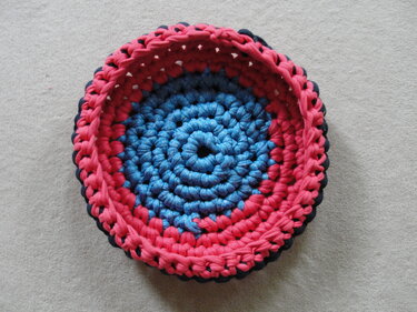 Runder gehäkelter Korb in Blau und Rot aus dickem Textilgarn