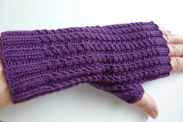 Lila gestrickte fingerlose Armstulpe mit Daumenloch an einer Hand