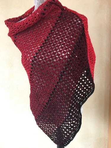 Gehäkeltes Dreieckstuch in Bordeauxrot bis Schwarz, auf einer Schneiderpuppe drapiert, mit filigranem Lochmuster.