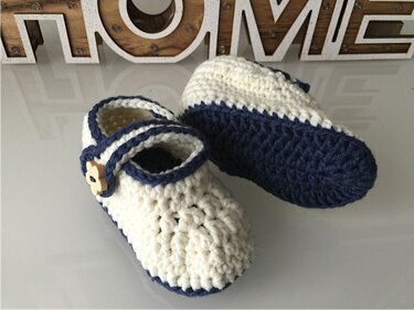 Gehäkelte Babyschuhe in Creme und Marineblau mit Holz-Blumenknopf