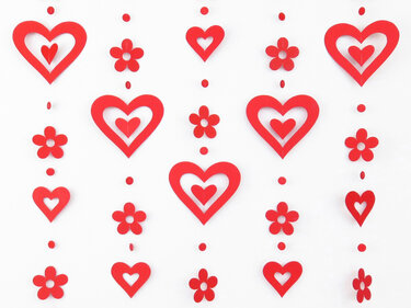 Vertikale Reihen aus roten Papierherzen und Papierblumen vor weißem Hintergrund