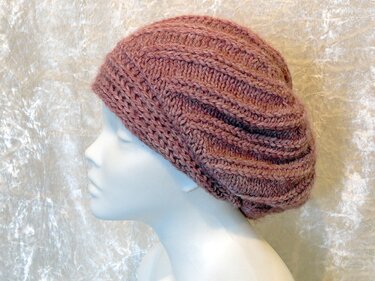 Mannequin head wearing a chunky ribbed slouchy beret in muted rose