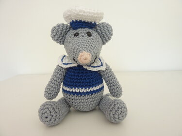 Gehäkelte graue Amigurumi‑Maus mit blau‑weißem Matrosenoutfit, sitzend