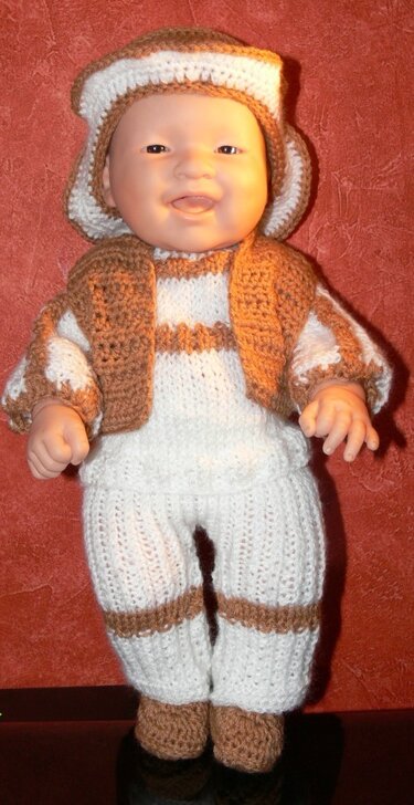 Babypuppe in gehäkeltem zweifarbigen Strampler mit kurzer Jacke und Mütze