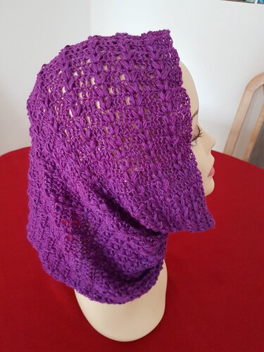 Lila gehäkelter Loop-Schal mit offenem Spitzenmuster auf einer Schaufensterpuppe