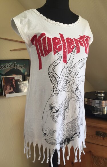 Mannequin trägt weißes umfunktioniertes T-Shirtkleid mit großem Ziegenkopf-Print, rotem Schriftzug, gehäkeltem Kragen und geschnittenen Fransen am Saum.