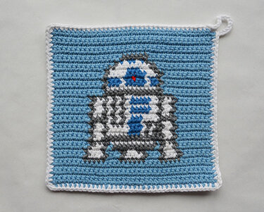 Gehäkelter Topflappen in Pixeloptik mit kleinem Robotermotiv