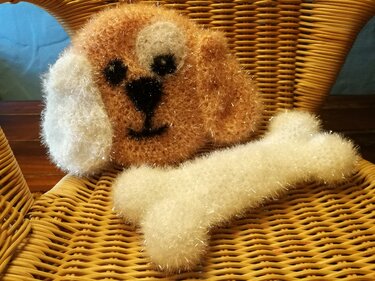 Gehäkeltes Hundegesicht aus flauschigem Effektgarn mit passendem Knochen