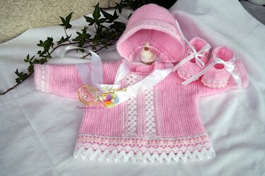 Gestricktes Baby-Outfit in Rosa mit Jäckchen, Haube und Babyschuhen, verziert mit weißen Bändern und feiner Spitze.