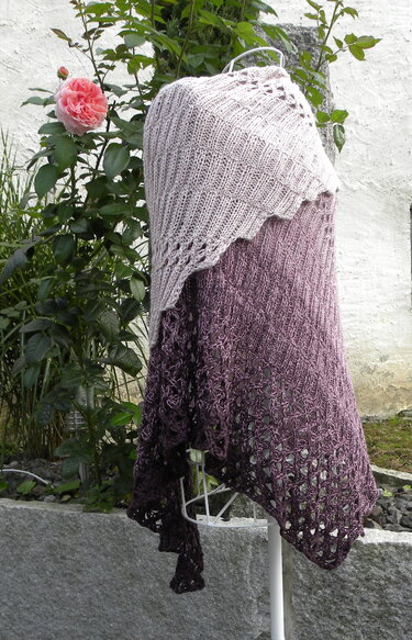 Gestricktes Dreieckstuch mit Farbverlauf von Rosé‑Beige zu Mauve auf Schneiderpuppe, mit Rippenmuster und Spitzenkante