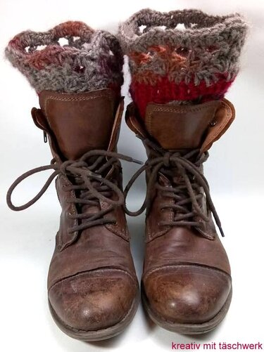 Braune Schnürstiefel mit mehrfarbigen, gehäkelten Stulpen am oberen Schaft