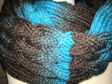 Nahaufnahme eines Loops mit sichtbarem Zopfmuster und Farbwechsel Braun-Türkis