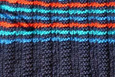 Gestrickter Stoff mit horizontalen Streifen in dunkelblau, orange, türkis und hellblau