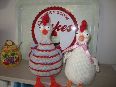 Zwei gehäkelte Amigurumi-Hühner mit tropfenförmigen Körpern, Kamm, Schnabel und kleinen Beinen