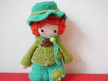 Gehäkelte Amigurumi-Puppe mit roten Locken und grünem Outfit