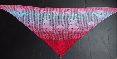 Dreieckstuch gehäkelt im Rot-Rosa-Türkis-Farbverlauf mit Filet-Hasen- und Blumenmotiven auf dunklem Untergrund