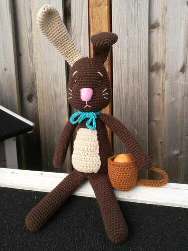 Gehäkelter brauner Hase mit beigem Bauch, rosa Nase und kleinem Korb