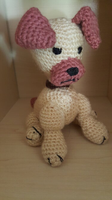Sitzender Amigurumi-Hund in Beige mit rosa Ohren und Schnauze