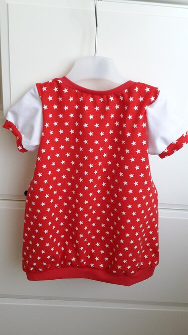 Rotes Baby-Top mit weißen Sternchen an einem Kleiderbügel