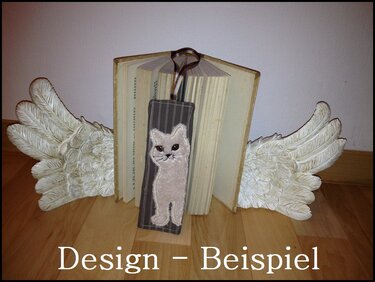 Lesezeichen mit applizierter Katze auf gestreiftem Stoff, eingespannt in ein geöffnetes Buch zwischen dekorativen Buchstützen