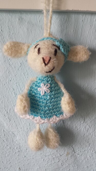 Gehäkeltes weißes Lamm mit hellblauem Kleid und Aufhängeschlaufe