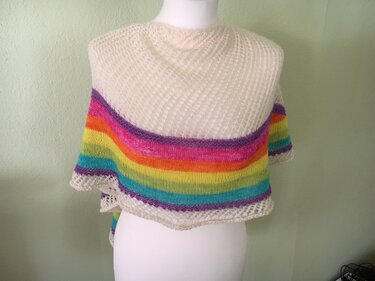 Gestricktes Schultertuch in Creme mit bunten Regenbogenstreifen auf einer Büste