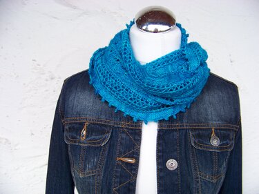 Türkiser gestrickter Loop-Schal auf Schaufensterpuppe mit Jeansjacke